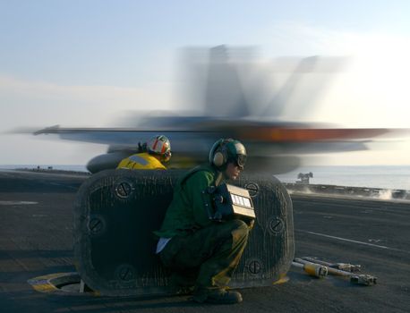 An F-18 Super Hornet rockets down the catapult track of a nuclear powered aircraft carrier