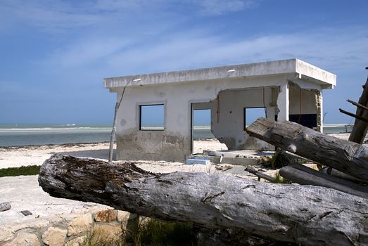 A storm shattered house sits on an idyllic beach