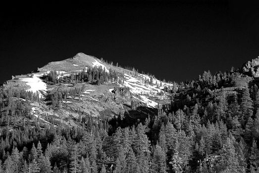 A dramatic black and white image of a snow covered mountain