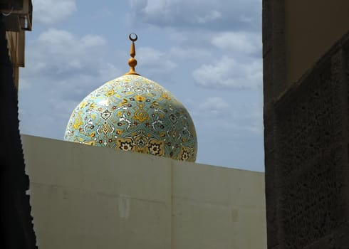 A Shite Mosque's dome stands out against the midday sky