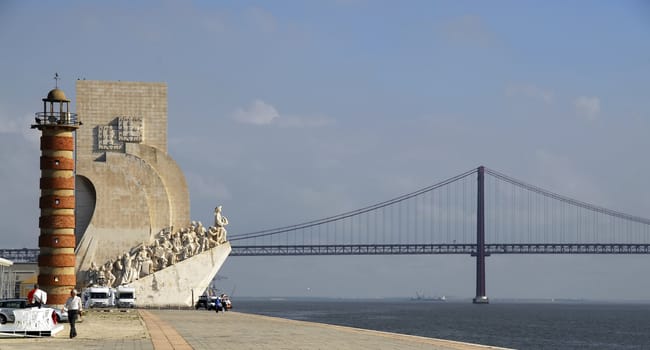 The Discoveries Monument and 25th of April Bridge in Lisbon, Portugal