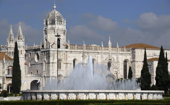 A classic European Monastery with a beautiful fountain in front of it