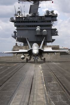 An F-18 Hornet sits ready on a catapult on board an aircraft carrier