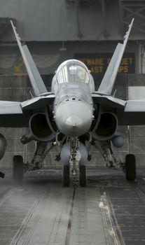 An F-18 hornet sits ready on a catapult onboard an aircraft carrier