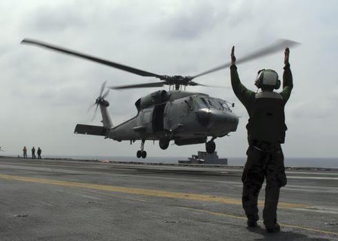 An SH-60 Seahawk launches from the deck of an aircraft carrier
