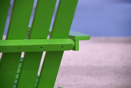 A bright green beach chair breaks the monotone stretch of a tropical beach