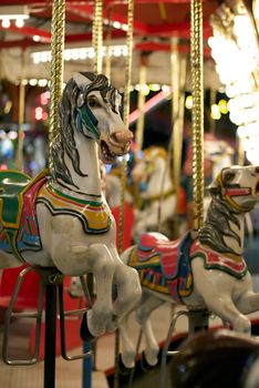 Hand painted horses on a carousel  at a carnival at night
