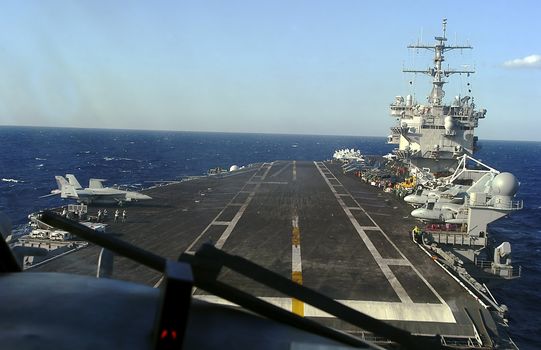 A unique view of an aircraft carrier from the perspective of a pilot about to land on it...                                