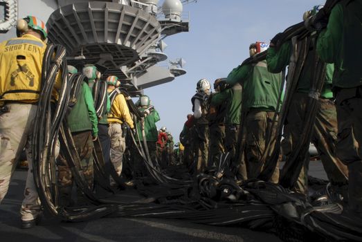 Sailors on board an aircraft carrier set up an emergency barricade