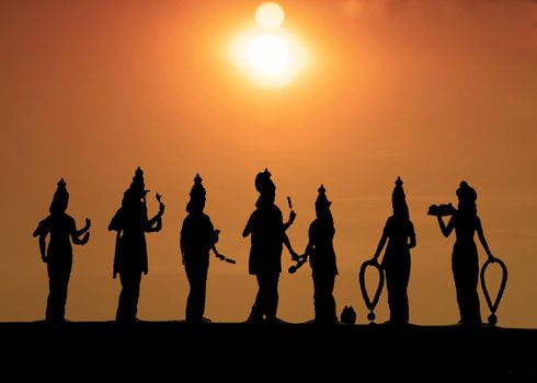 Statues portraying the Buddist deities are set against an awe inspiring sunset in Kualal Lumpur