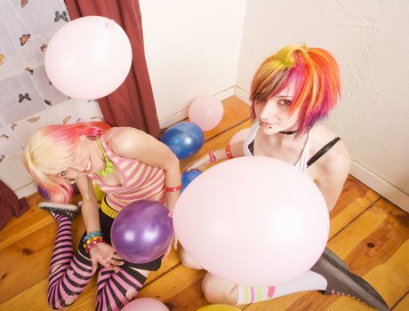 Two punk girls in a room with colorful balloons