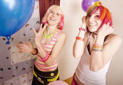 Two punk girls in a room with colorful balloons