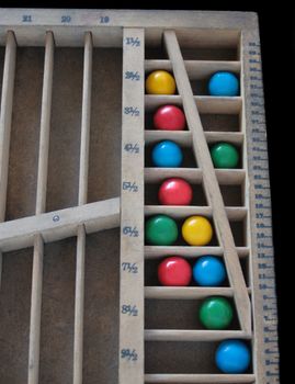 colorful balls in a printer's quarter-size wood rule case
