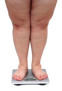 women legs with overweight standing on bathroom scales