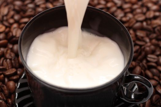 coffee beans and pouring milk into cup