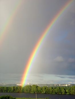 vertical landscape with rainbow over lake after storm