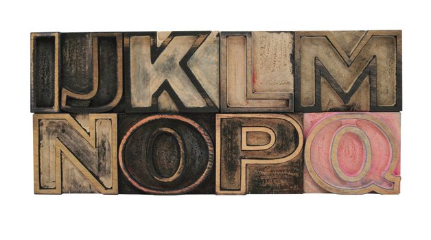 old, ink-stained letterpress wood outline type letters I-Q