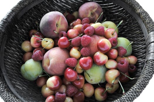summer's bountiful and colorful fruits in a dark round basket
