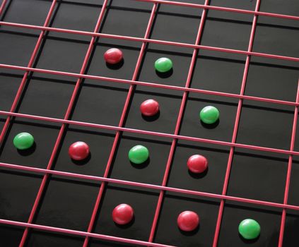 red and green discs within a red grid on top of a reflective black surface
