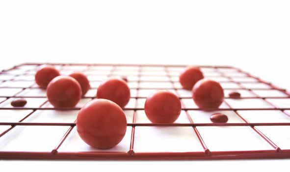 red spheres and discs on a red grid on a white background