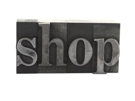 old, ink-stained metal letterpress type spells out the word 'shop' isolated on white