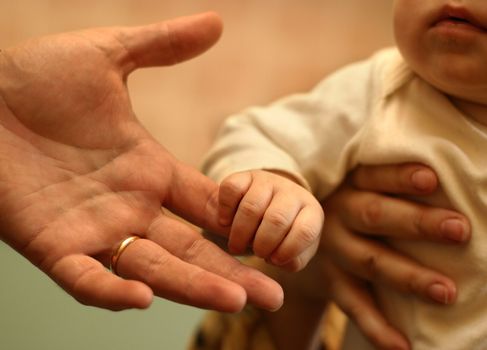 The image of hands of parents and the kid