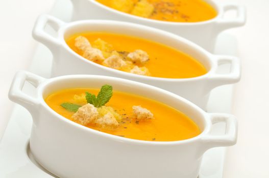 Carrot creamy soup served in small ceramic bowls