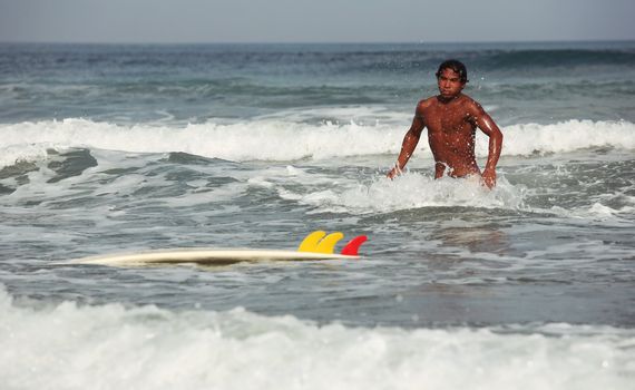 Young men - the surfer in ocean. Bali