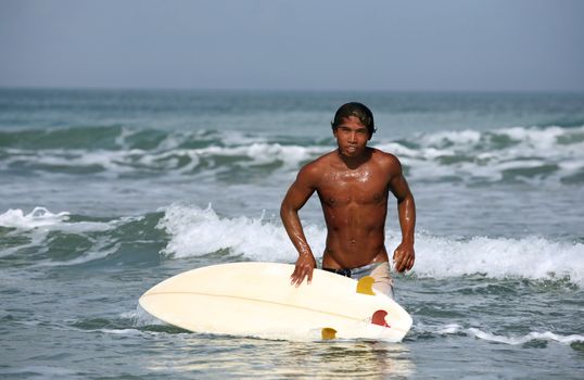 Portrait young men - the surfer in ocean. Bali
