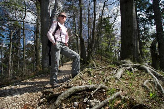 Young female backpacker standing in the forest