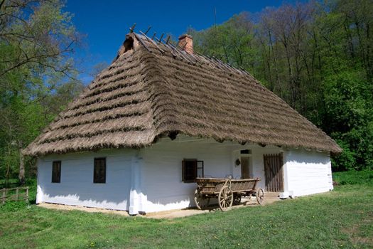 Very old polish white hut with thatched roof