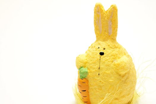 Stuffed bunny with carrot over white background