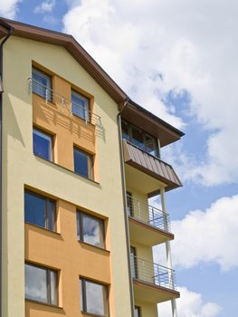 flat building against the blue sky with clouds