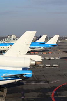 The tails of waiting airplanes on the gate 