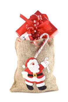 Bag with santa print, full of christmas presents isolated on white.