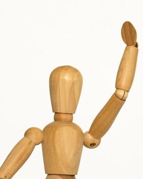 wooden artist mannequin with its arm raised in a waving position