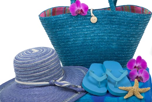 Colorful summer beachwear, flipflops, towel, bag, hat, orchids and starfish