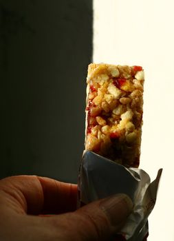 nutty and fruity chewy cereal bar held in a hand