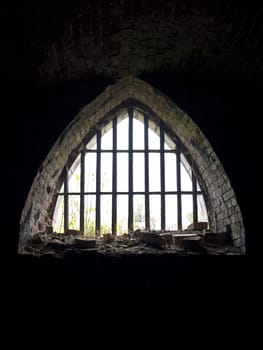 old arch window with metallic treillage in dark 