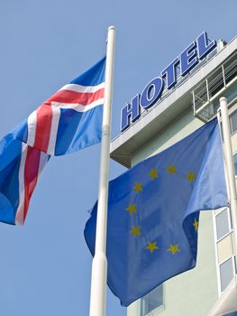 Blue yellow European flag with other fluttering in front of the hotel