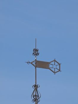 Metallic weather vane against the blue sky