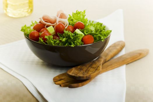 Prosciutto salad with wooden spoon on the table