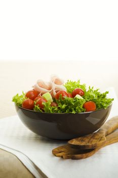 Prosciutto salad with wooden spoon on the table