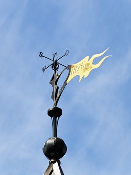 Metallic weather vane against the blue sky