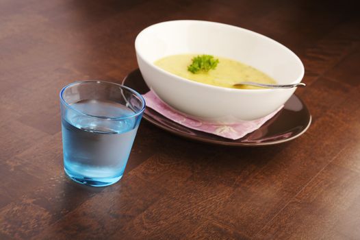 Yellow vegetable soup on a dark wooden table