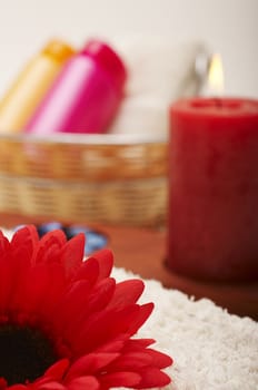 Spa settings with flower, shampoo, candle and towel