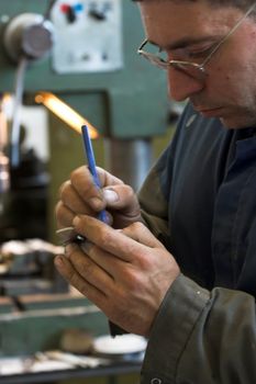 Worker and old gear in vintage workshop