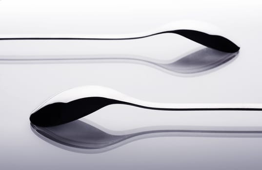 Two shiny spoons on the table