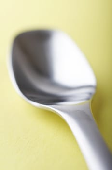 spoon close up on the yellow background 