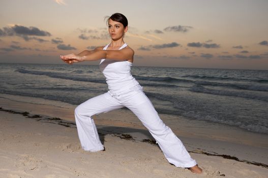 Young beautiful woman during fitness on sea beach 